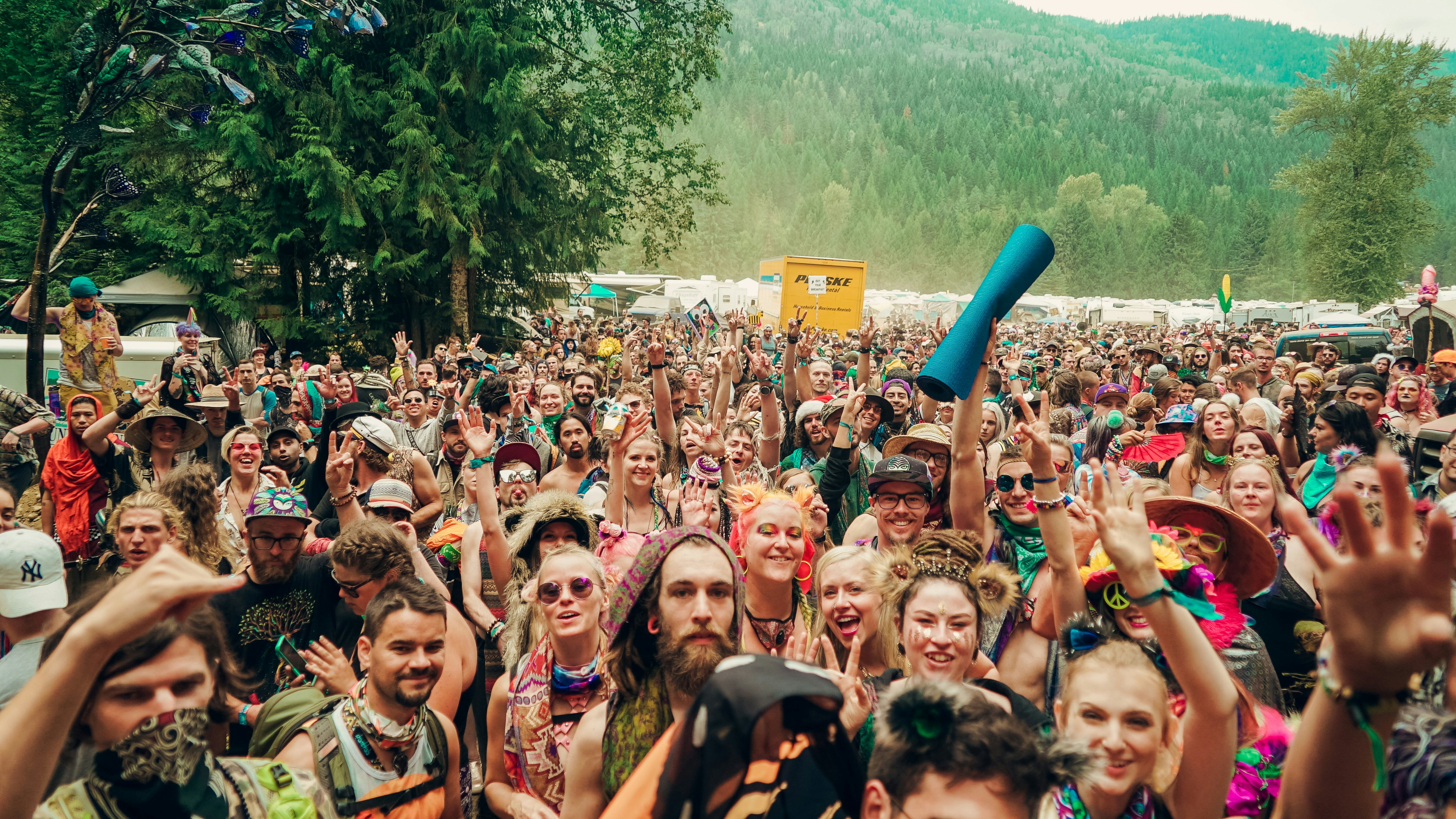 A vibrant, tech-forward music festival at night with a large crowd