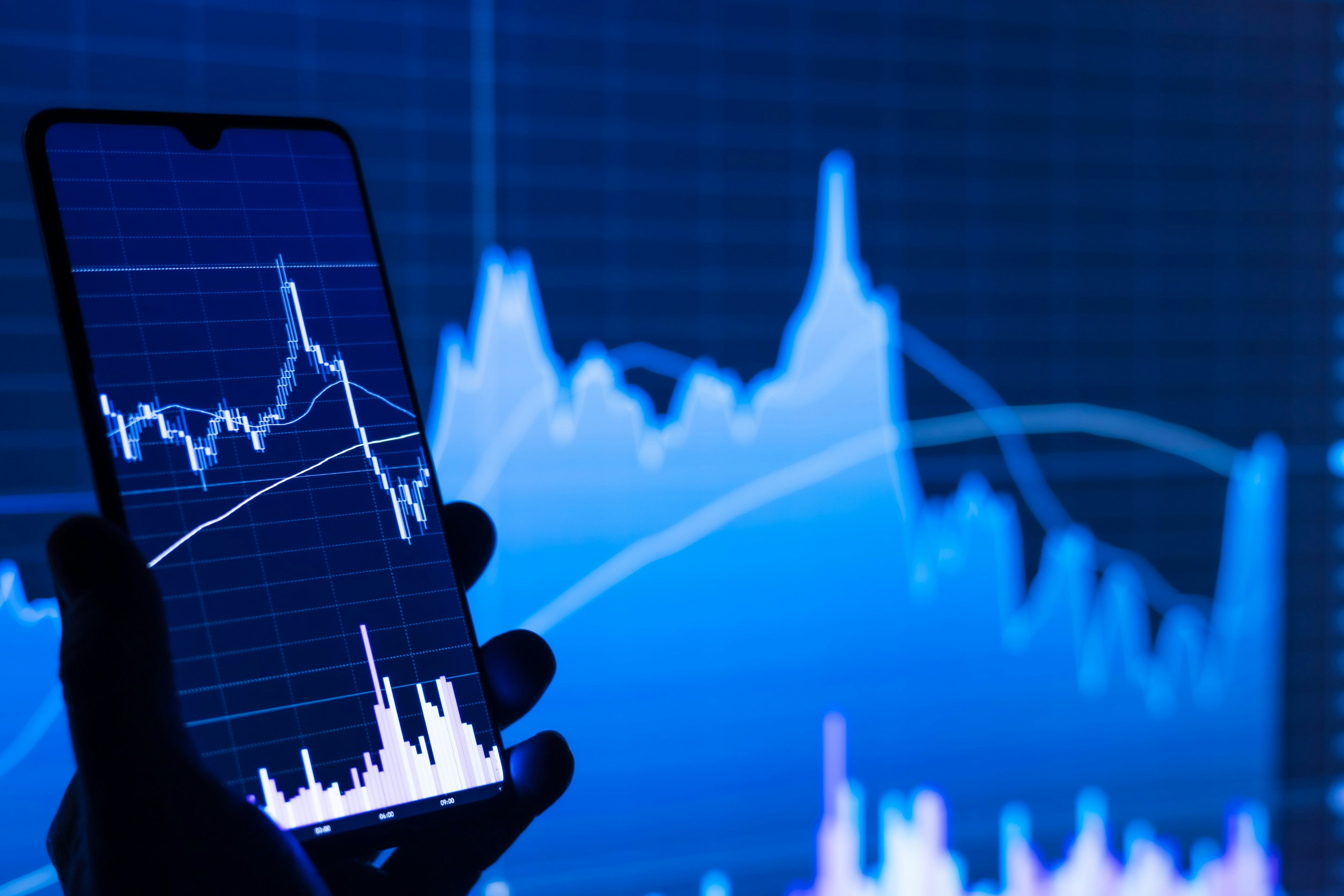 A professional pointing at a stock market graph on a tablet