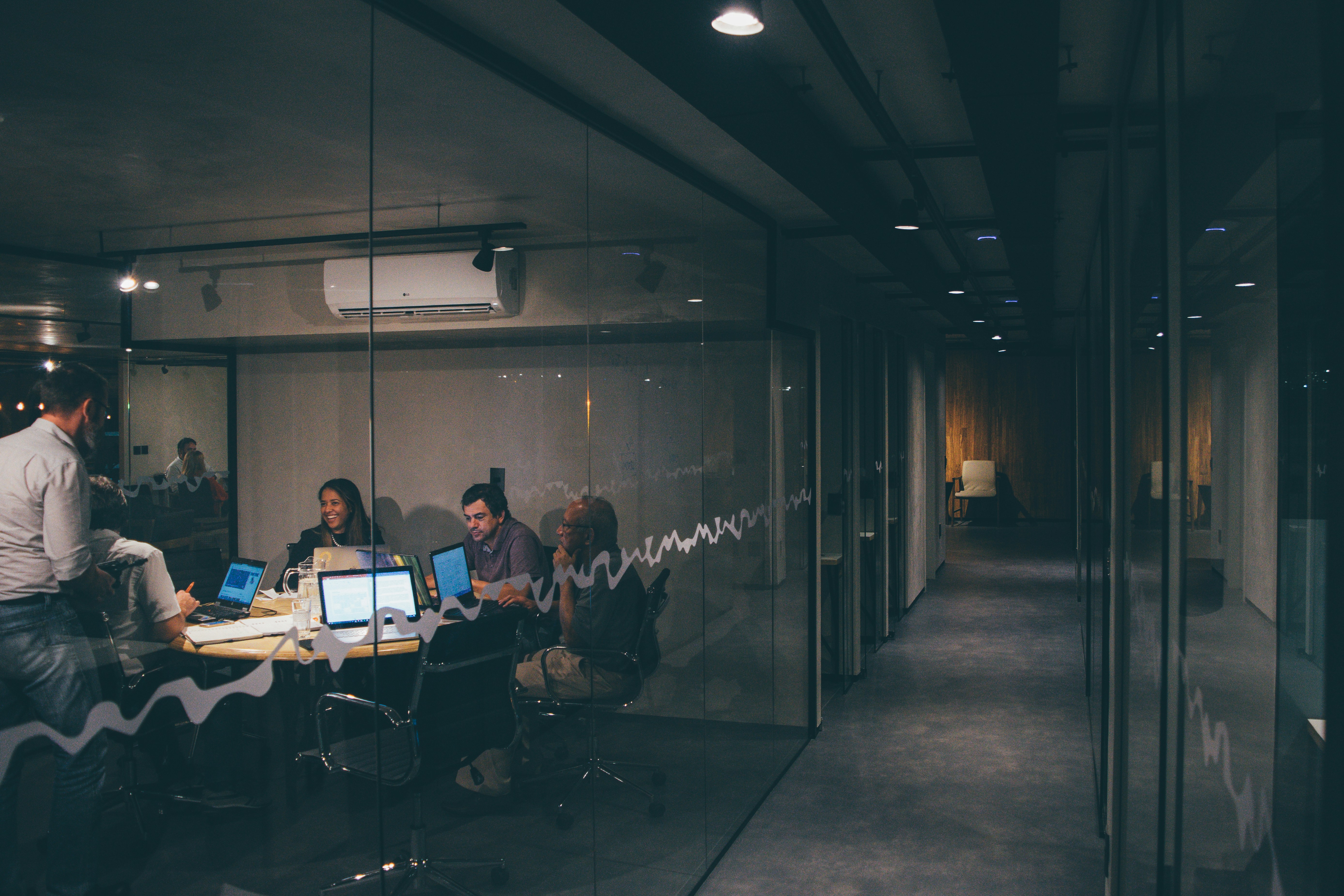 A team of marketing professionals analyzing data on a large screen in a modern Kuala Lumpur office.